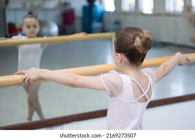 Cute Little Girl Toddler Ballerina In Pale Pink Tutu And Ballet Shoes Practicing Dance Moves.