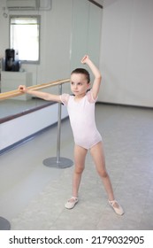 Cute Little Girl Toddler Ballerina In Pale Pink Tutu And Ballet Shoes Practicing Dance Moves.