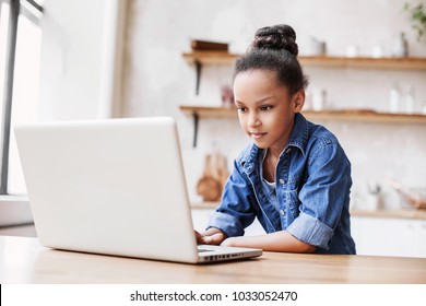 Cute little girl using laptop at home. Education, online study, home studying, technology, science, future, distance learning, homework, schoolgirl children lifestyle concept