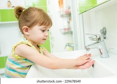 Cute Little Girl Washing Hands In Bathroom