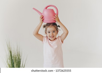 Cute Little Girl Watering Potted Plan. Very Emotional Child With A Watering Can. Isolated On White