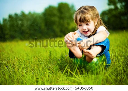 cute little girl with a water-melon on the grass in summertime