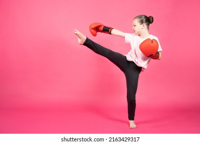 Cute Little Girl Wearing Boxing Gloves Practicing Karate Or Martial Arts Isolated On Pink Background. Child Learning Self Defense.