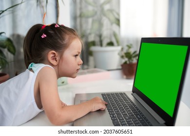 A cute little girl working with a laptop. Green screen for replacement - Powered by Shutterstock