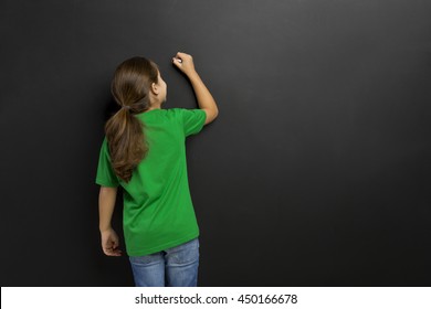 Cute little girl writing in a blackboard, with copy space. - Powered by Shutterstock