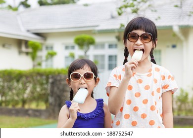 Cute little Girls Eating Ice Cream before their house