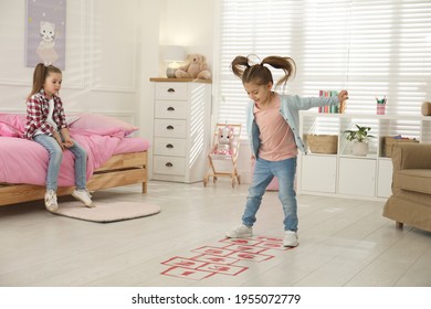 Cute Little Girls Playing Hopscotch At Home