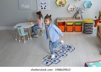 Cute Little Girls Playing Hopscotch At Home