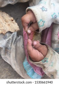 A Cute Little Hands Of A Kid Holding A Thin Stick While Playing In The Yard