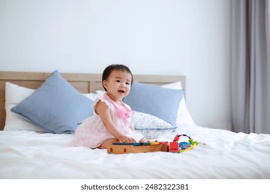 Cute little happy child girl sitting play colorful toys at bed in home room.Asian baby lifestyle and education. - Powered by Shutterstock