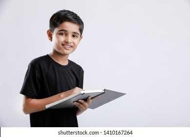 Cute little Indian / Asian boy reading book isolated over white background