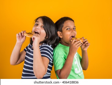 Cute Little Indian / Asian Boy And Girl Eating Pizza Over Yellow Background