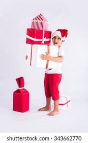 Cute Little Indian Boy Holding Christmas Gifts Stacked In Both Hands