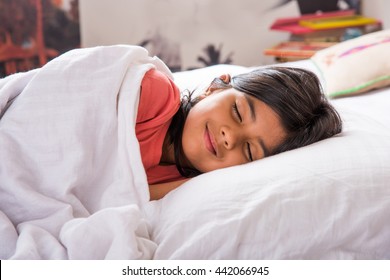 Cute Little Indian Girl Sleeping Over White Bed Sheet And Pillow. 