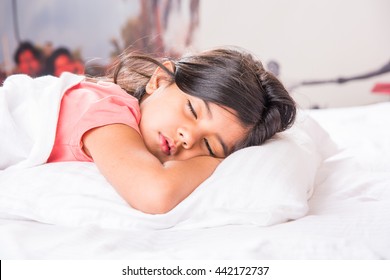 Cute Little Indian Girl Sleeping Over White Bed Sheet And Pillow. 