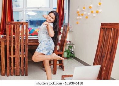 Cute little Indian girl taking online dancing class on a laptop at home