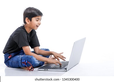 Cute Little Indian/Asian Boy Studying Or Playing Game With Laptop Computer