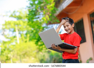 Cute Little Indian/Asian Boy Studying Or Playing Game With Laptop Computer