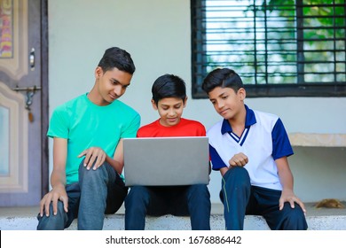 Cute Little Indian/Asian Boy Studying Or Playing Game With Laptop Computer