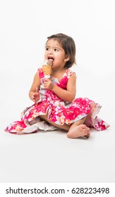 Cute Little Indian/asian Girl Child Licking Or Eating Chocolate Ice Cream In Cone, Isolated Over White Background