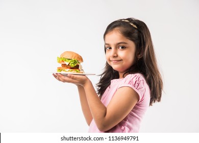 Cute Little Indian/Asian Girl Eating Burger On White Background
