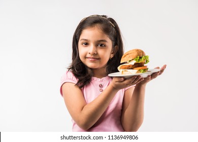 Cute Little Indian/Asian Girl Eating Burger On White Background
