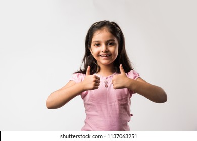 Cute Little Indian/asian Girl Showing Thumbs Up Sign, Standing Isolated Over White Background