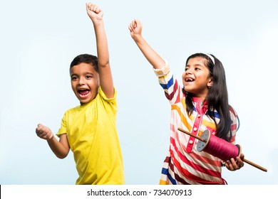 Cute Little Indian/asian Kids Flying Kite On Makar Sankranti Or Uttarayan Festival, Against Sky Blue Background