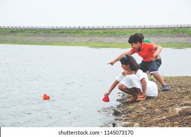 Cute Little Indian/asian Kids Playing With Paper Boats In Pond