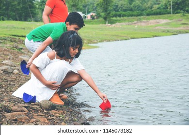 Cute Little Indian/asian Kids Playing With Paper Boats In Pond