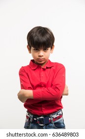 Cute Little Indian/asian Sad Kid/boy Standing Over White Background With Hands Folded And Looking At Camera