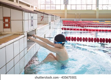 Cute Little Kid Boy Is Ready For Swimming Competition  In The Sport Swimming Pool. Child Ready To Jump And Swimming Race. Training For Competition. Sport Activities For Children Indoors.