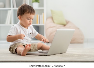 Cute little kid computing on the floor