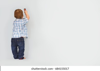 Cute Little Kid Drawing New Year 2017 With Painting Brush On Wall Background