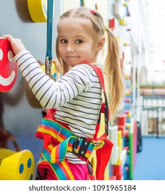 Cute Little Kid Girl In Sport Equipment Climbing