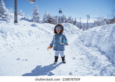 cute little kid walking alone in the middle of snowy mountain