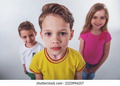 Cute little kids are looking at camera and smiling, handsome little boy in the foreground, isolated on a white background - Shutterstock ID 2223996257