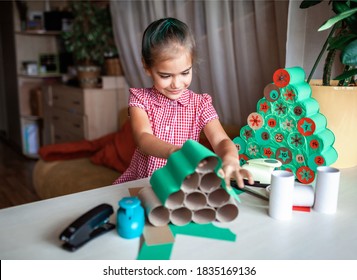 Cute little kids making handmade advent calendar with toilet paper rolls at home. Glue, colored paper, cut punch to hide sweets and candies in rolls. Seasonal activity for kids, zero waste holidays - Powered by Shutterstock