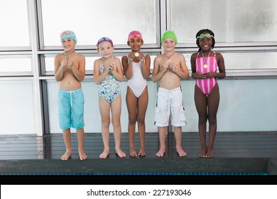 Cute little kids standing poolside with medals at the leisure center - Powered by Shutterstock