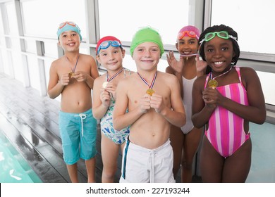 Cute little kids standing poolside with medals at the leisure center - Powered by Shutterstock