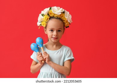 Cute Little Mexican Girl In Floral Wreath With Maracas On Red Background