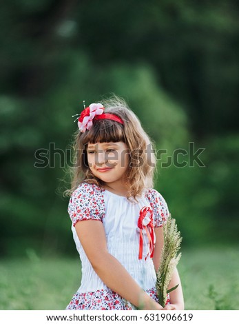 Cute little model girl with loose hair on nature background.