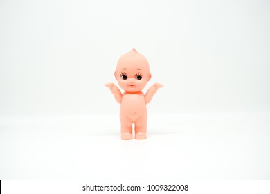 Cute Little Naked Baby Doll Standing On White Isolated Background.