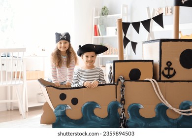 Cute little pirates playing in cardboard ship at home - Powered by Shutterstock