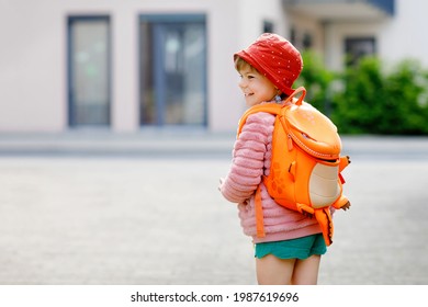 Cute little preschool girl going to playschool. Healthy toddler child walking to nursery school and kindergarten. Happy child with backpack on the city street, outdoors.