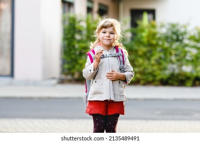 Cute little preschool girl going to playschool. Healthy toddler child walking to nursery school and kindergarten. Happy child with backpack on the city street, outdoors.