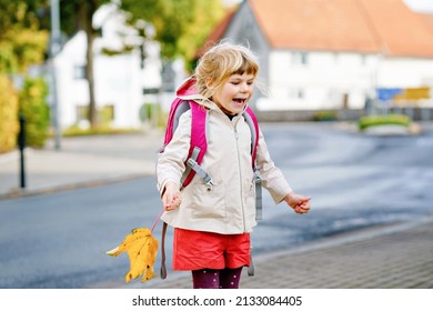 Cute little preschool girl on her first day going to playschool. Healthy happy child walking to nursery school. Kid with backpack going to day care on the city street, outdoors