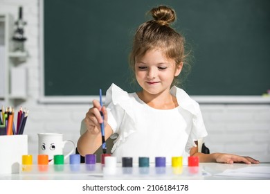 Cute Little Preschooler Child Girl Drawing At School. Child Girl Painting On Elementary School. Little Funny Artist Painting, Drawing Art.