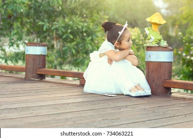 The Cute Little Princess And The Frog Prince On The Bridge In The Beautiful Light.