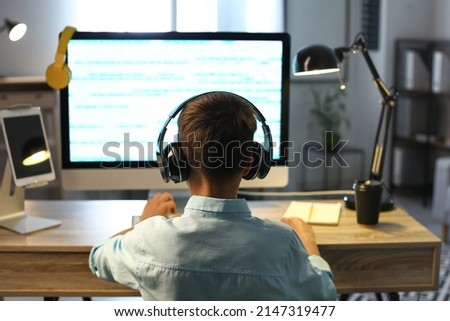 Cute little programmer using modern computer at home, back view